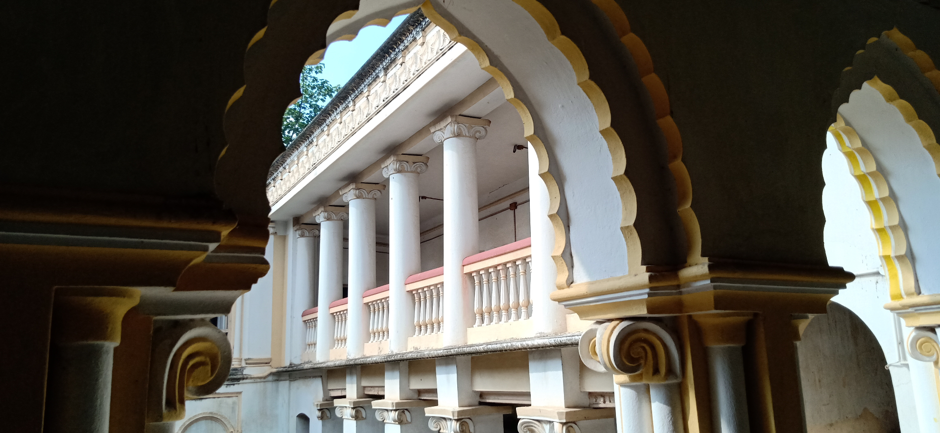 Scalloped arches framing the pillared balcony at Heritage Homestays