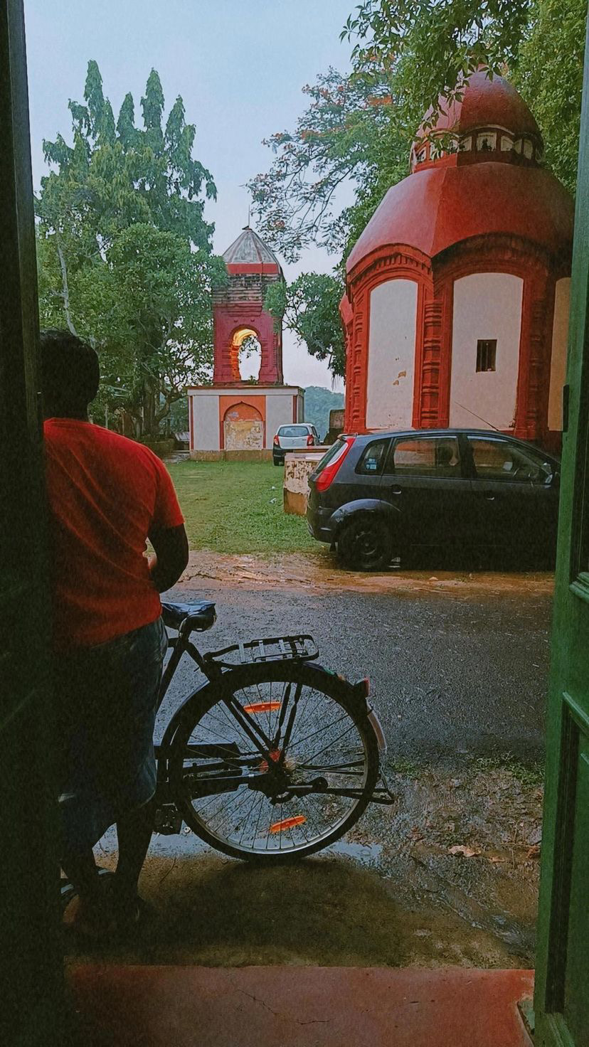Temple courtyard seen through a doorway in the rain